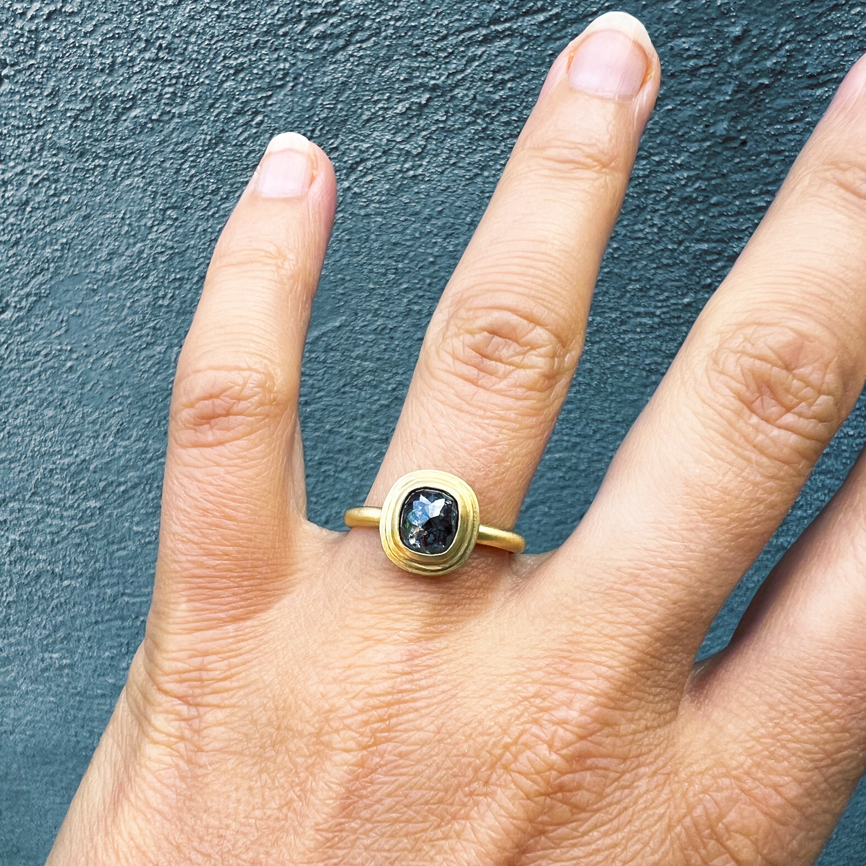 18ct Cushion Cut Diamond Ring worn on a hand, showing the salt and pepper diamond up close.