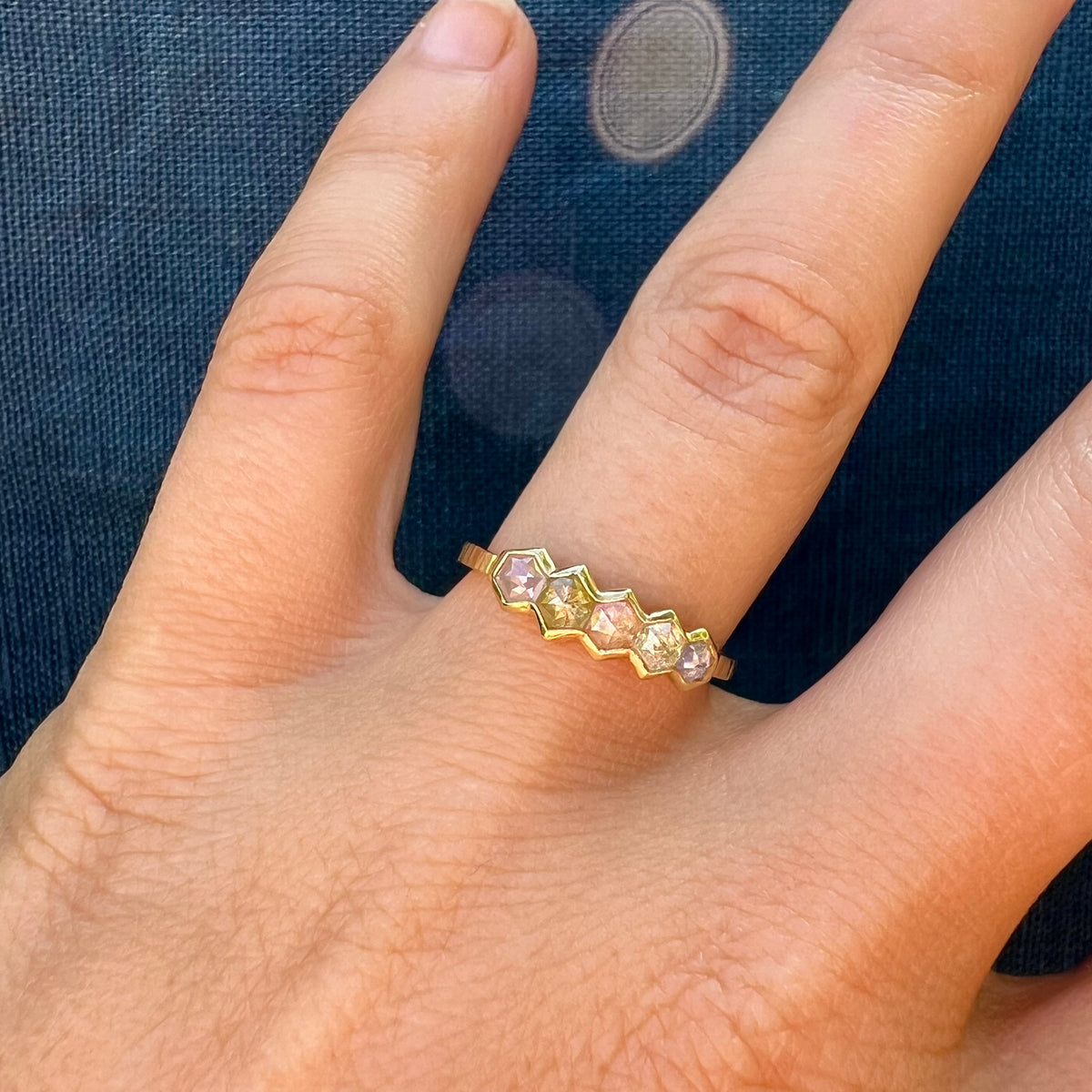 18ct Gold & Hexagon Diamond Ring worn on a hand, showing the row of hexagon diamonds up close.
