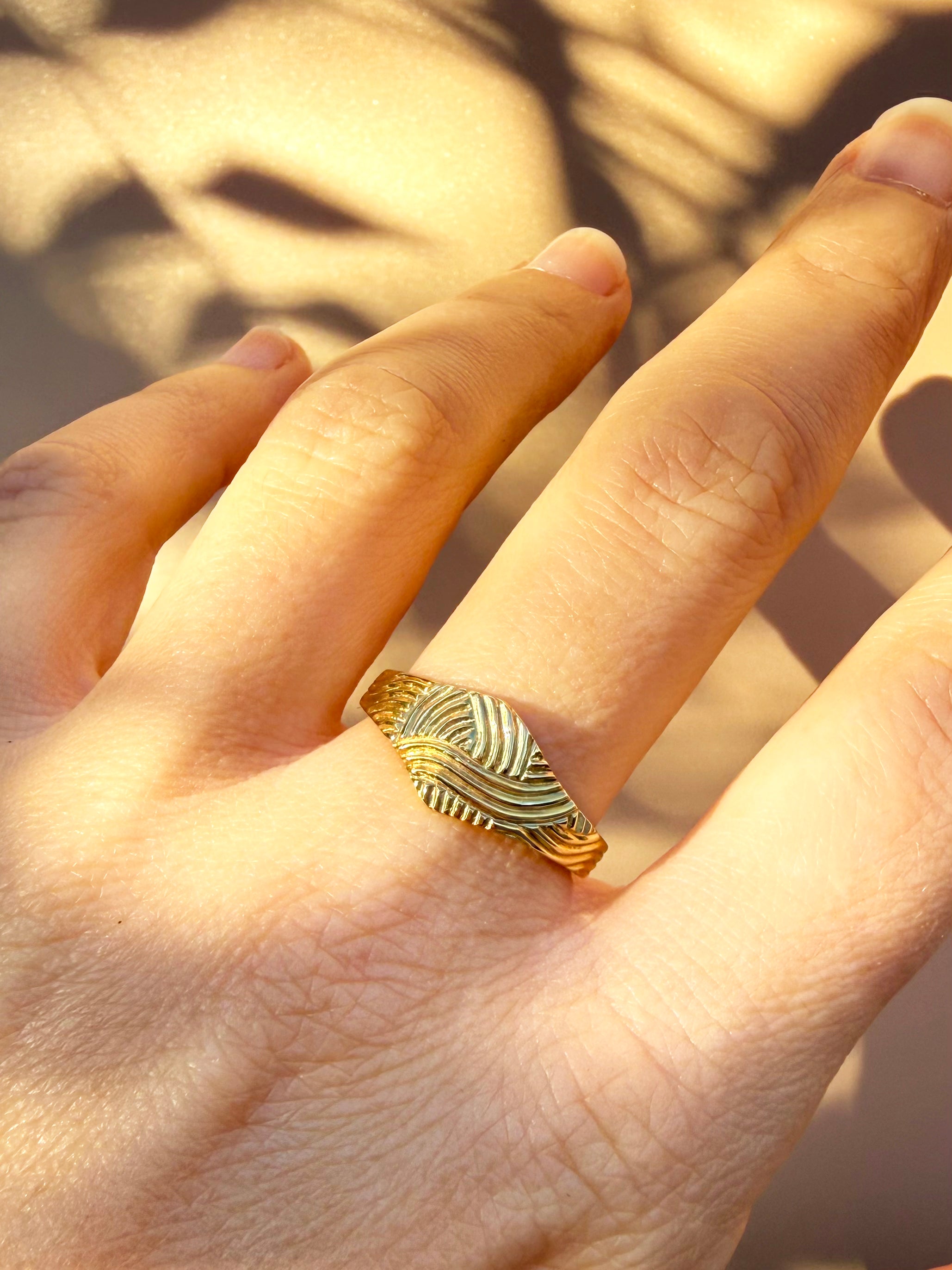 Gold Patterned Signet Ring worn on a hand, showing the hand-carved pattern up close.