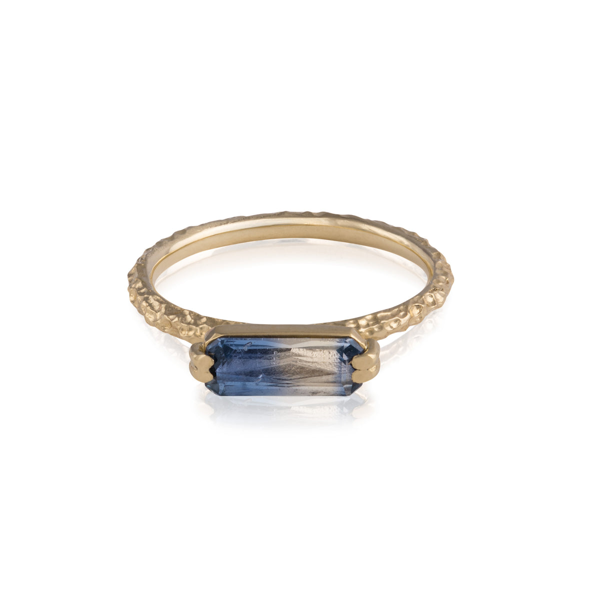 18ct gold ring with a rippling dappled band set with a bi-colour sapphire, fading from pale blue to indigo